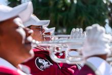 Looking through a row of FSU Marching Chiefs trumpet players as they play during the Homecoming Parade