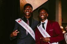 Two male students wearing suits and 2024 Homecoming Court sashes 