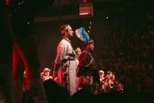 Three people standing on the Homecoming Live stage dressed in Seminole Tribe of Florida regalia